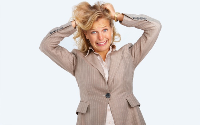 Closeup portrait of a frustrated young woman with hands in hair isolated on white background